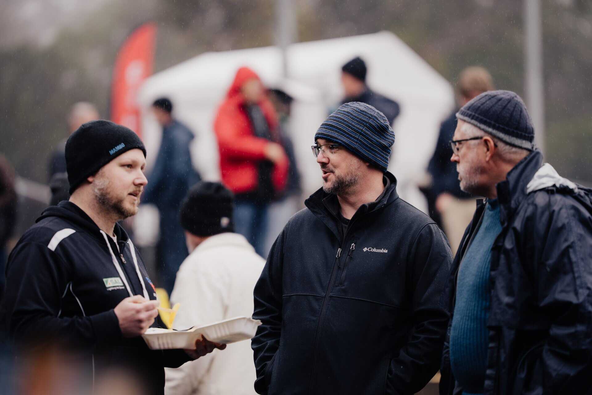 Outdoor gathering featuring people chatting at a community event in Australia.